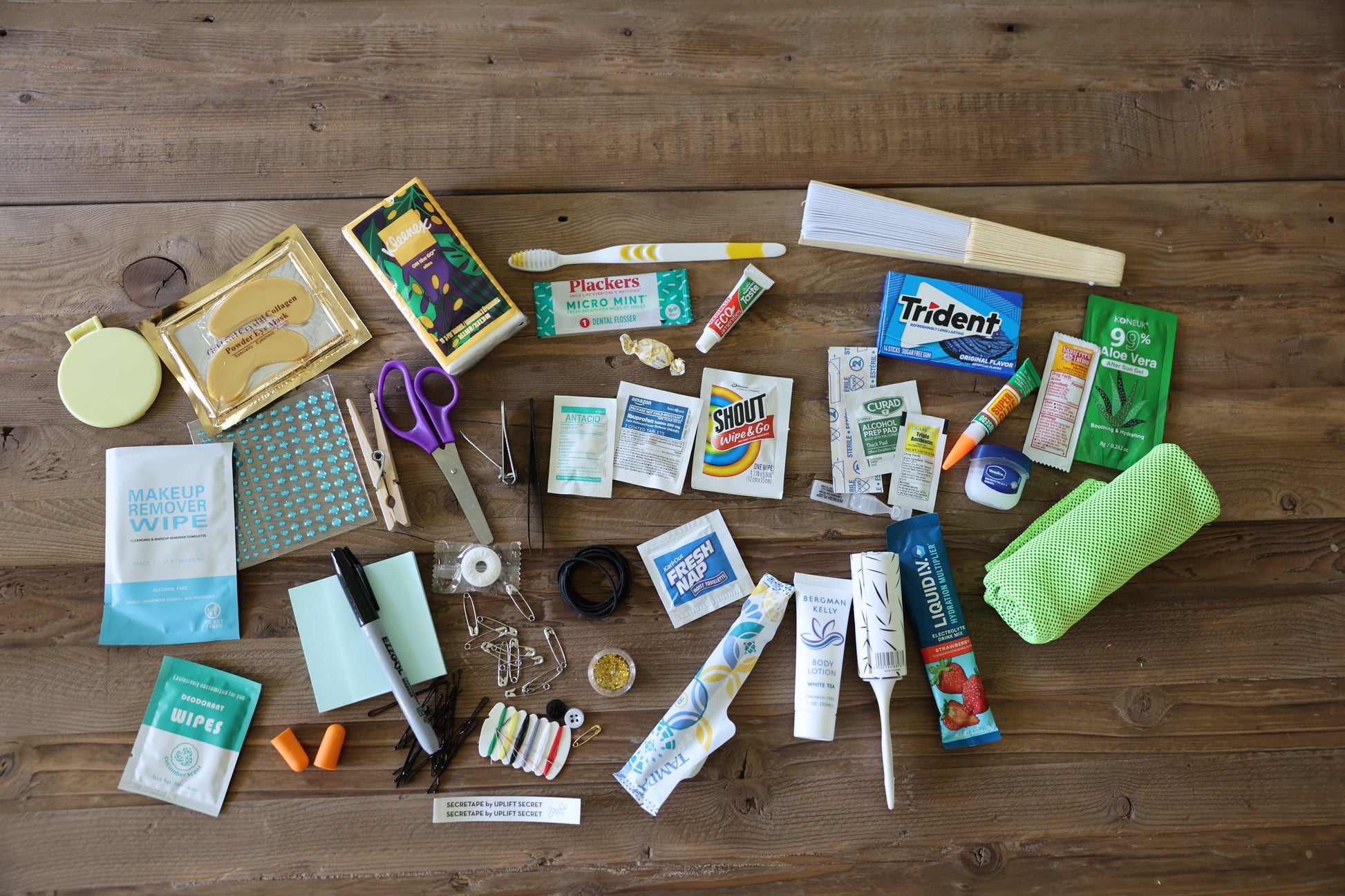 Collection of various items including snacks, cleaning supplies, and stationery on a wooden surface.