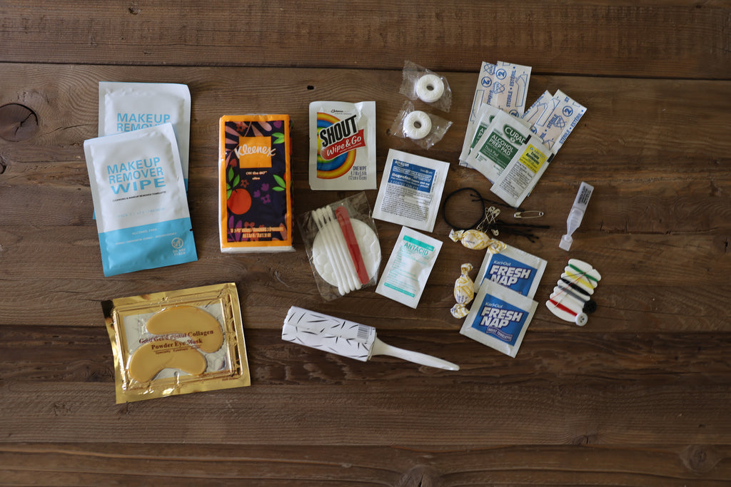 Collection of various items including a eye mask, lint roller, and cleaning supplies on a wooden surface.