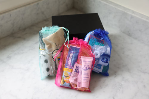 Assorted small products including lotion, a pouch, and a box on a marble surface.